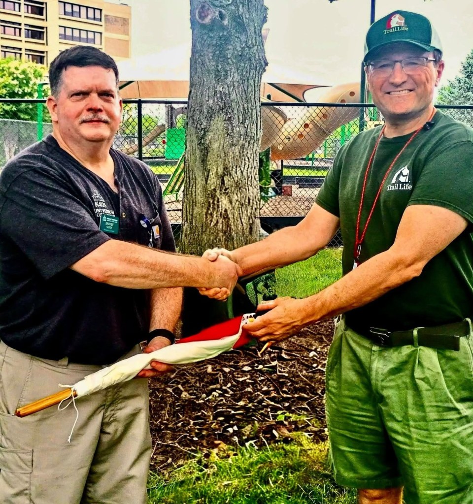 MVARC president shaking hands with the Trail Life club leader while presenting semaphore signaling flags